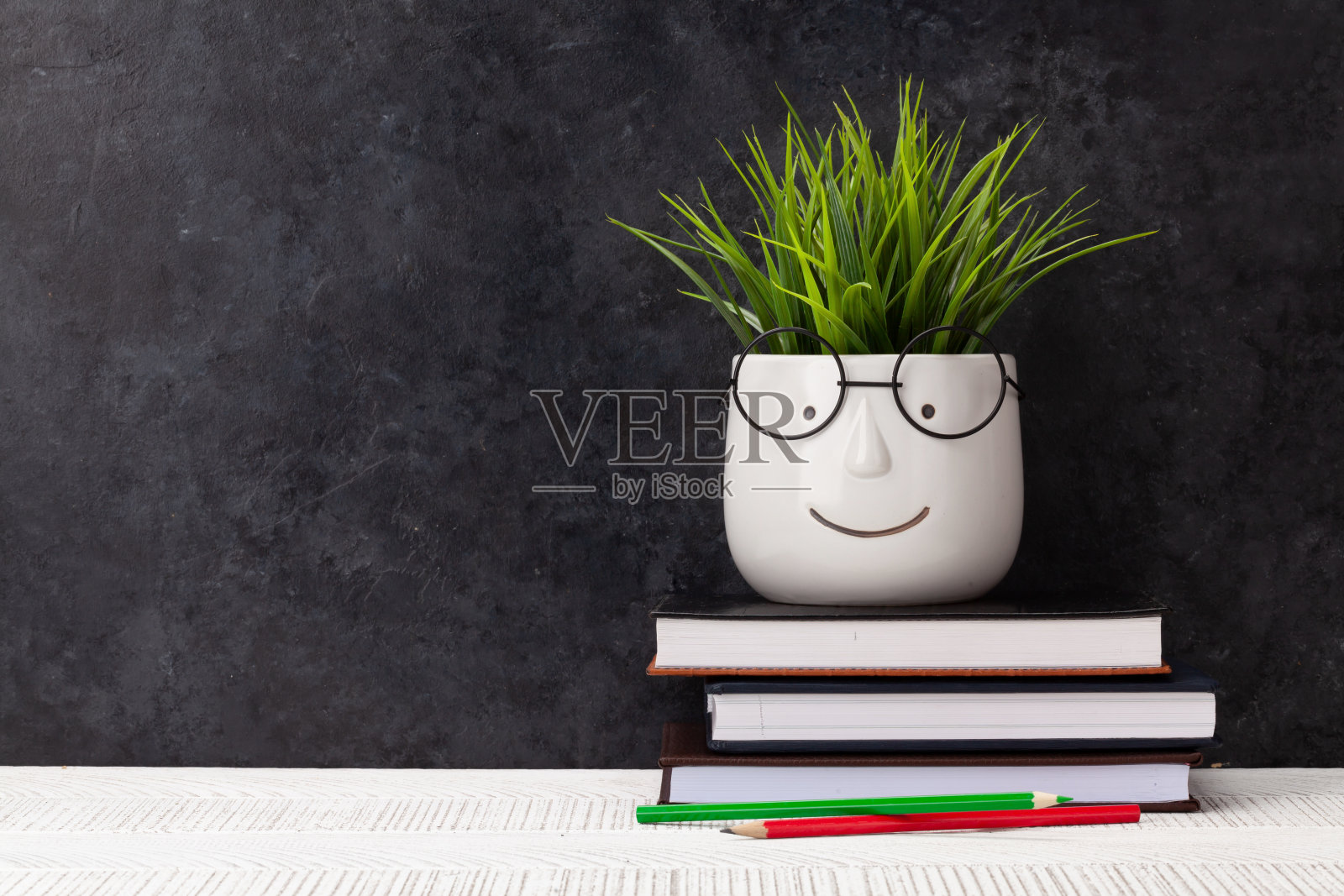 桌子上有记事本，植物上有眼镜照片摄影图片