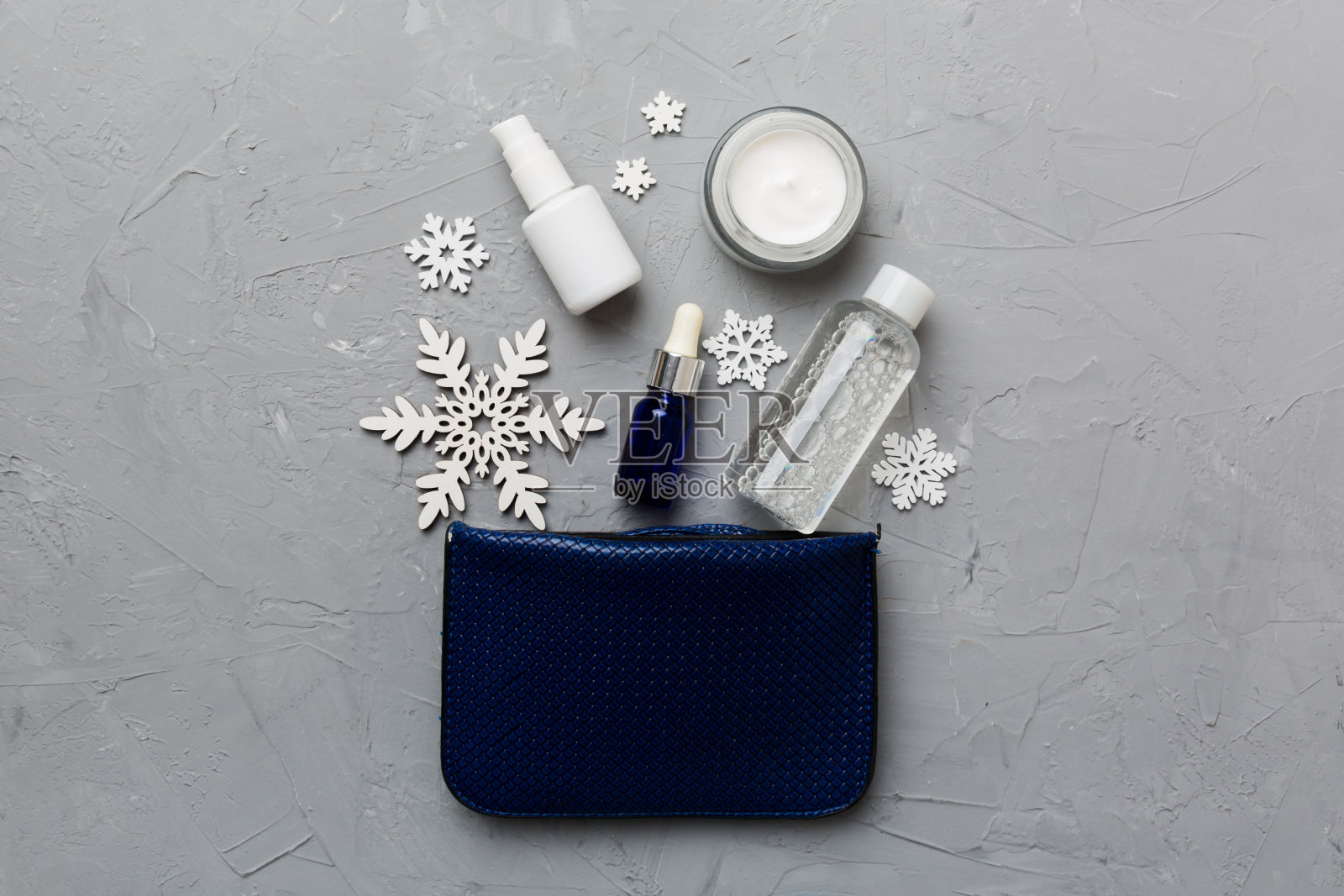 圣诞平放彩妆化妆用品在彩妆包上以彩色为背景。俯视图新年美容概念照片摄影图片