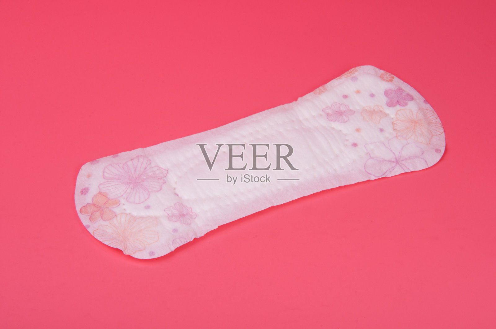 粉红色背景的棉质医用毛巾或卫生巾适用于危重期的女性。关心和保护。照片摄影图片