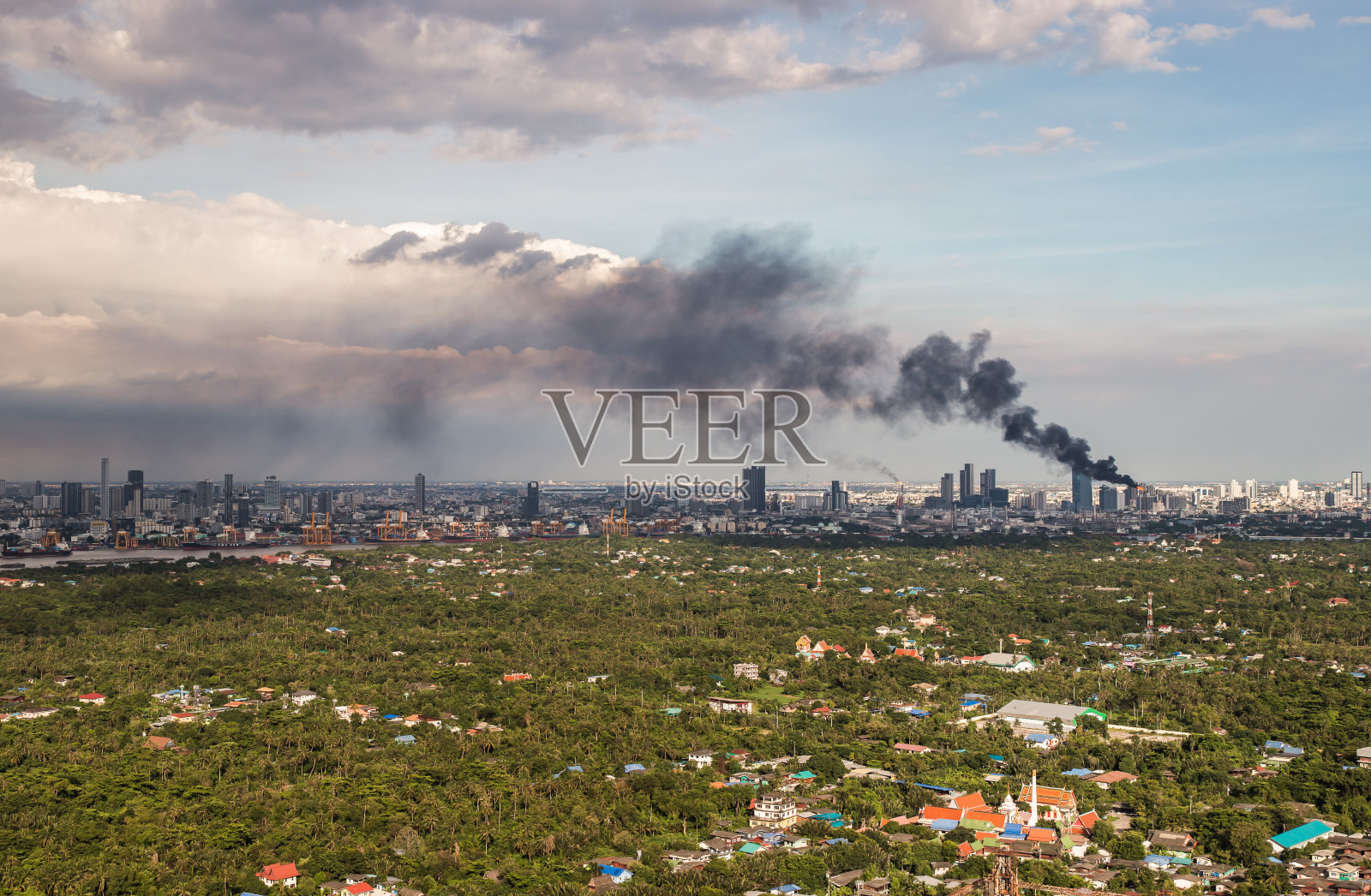 在城市的一些地区，从燃烧的工业或办公大楼中冒出的浓烟。照片摄影图片