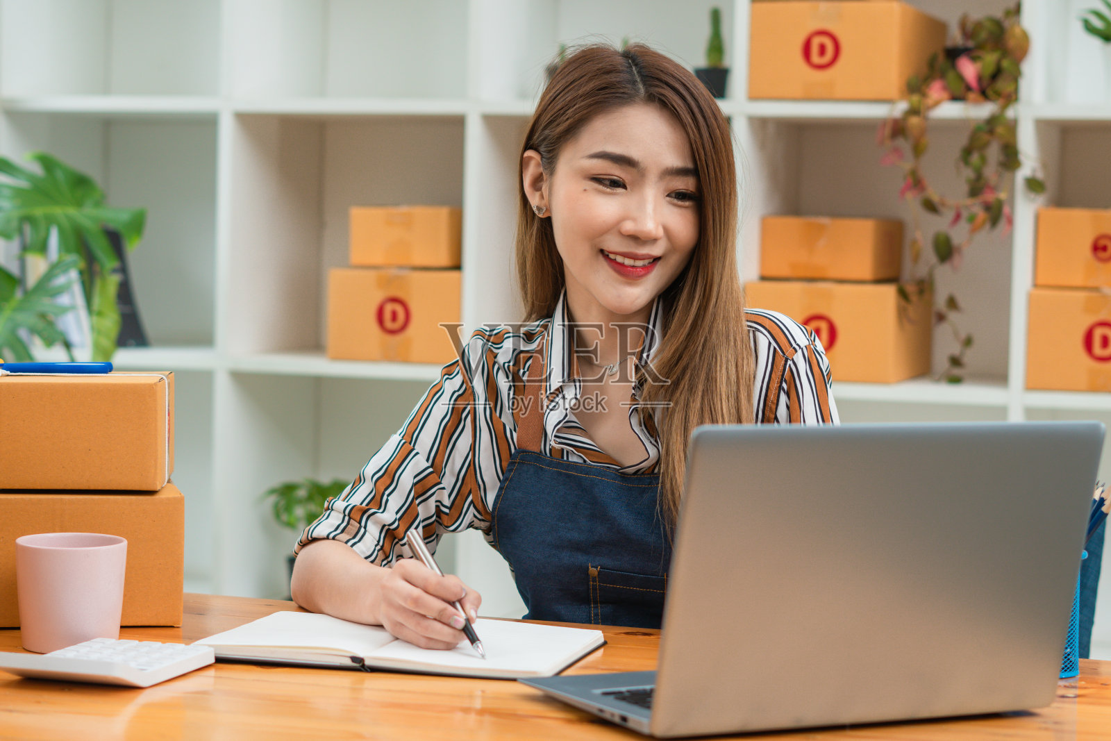 年轻的创业小企业企业家女性工作与电脑笔记本电脑在家里，在线业务，电子商务和交付概念。照片摄影图片