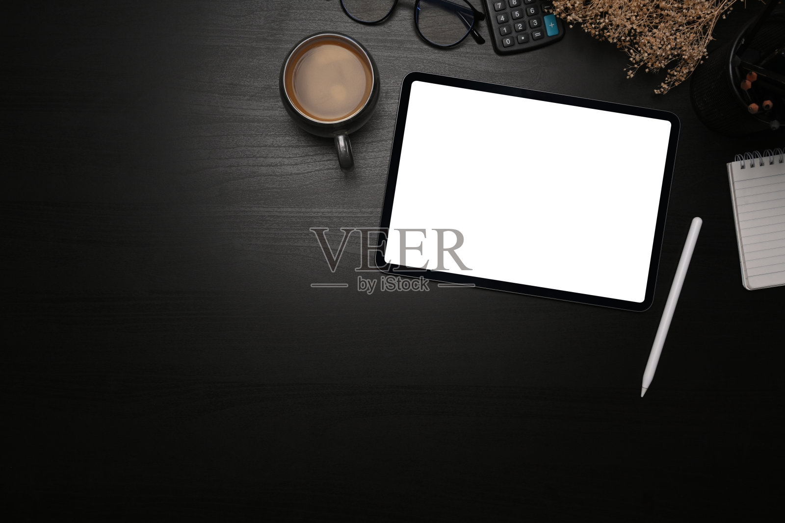 上面的视图模拟数字平板电脑，手写笔和咖啡杯在黑色的桌子上。照片摄影图片