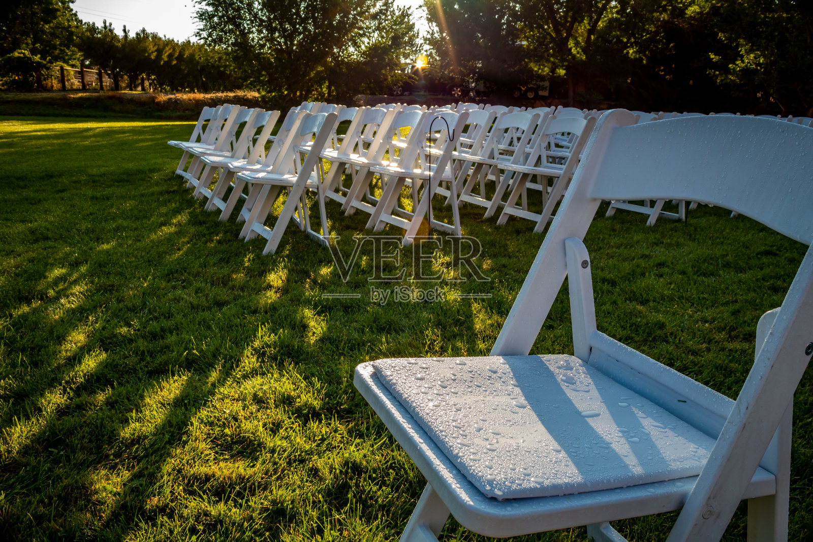 户外婚礼布置，有椅子，绿草和日落。照片摄影图片