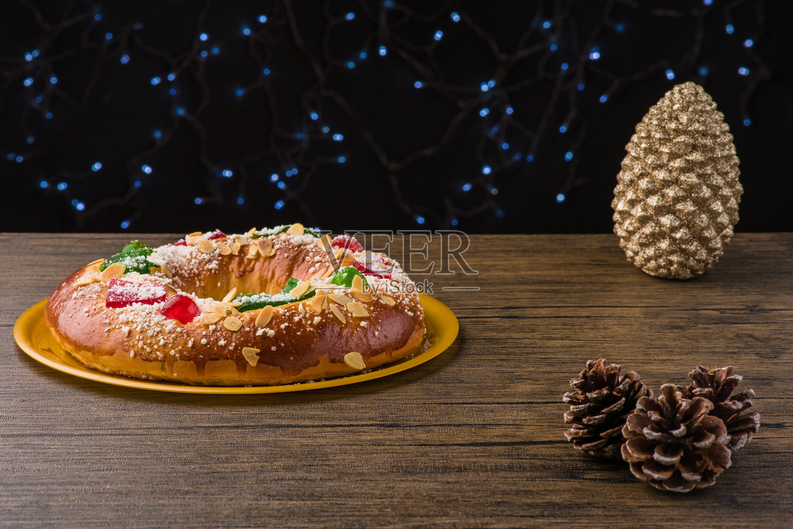 传统的西班牙圣诞食物蛋糕。Roscon de reyes背景与木制桌子上的装饰品照片摄影图片