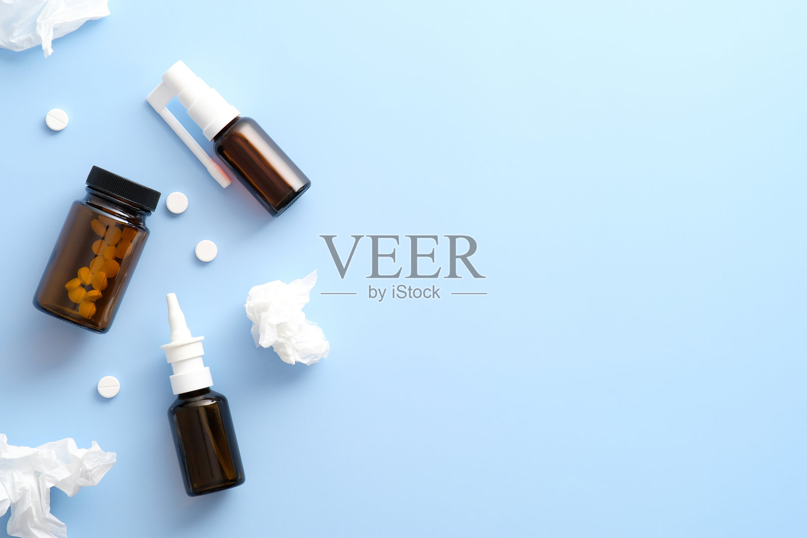 蓝色背景上有药片、滴鼻剂、止咳喷雾剂。医疗旗帜设计。照片摄影图片