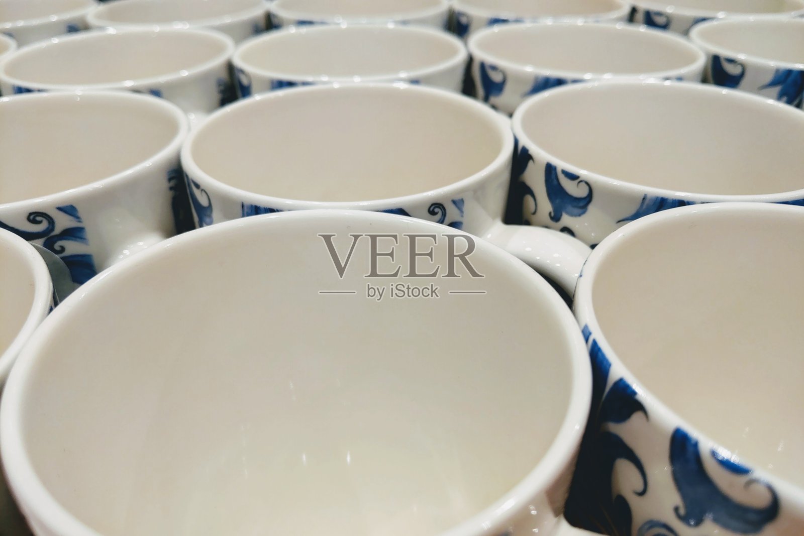 在零售商礼品店的货架上的彩色杯子。照片摄影图片