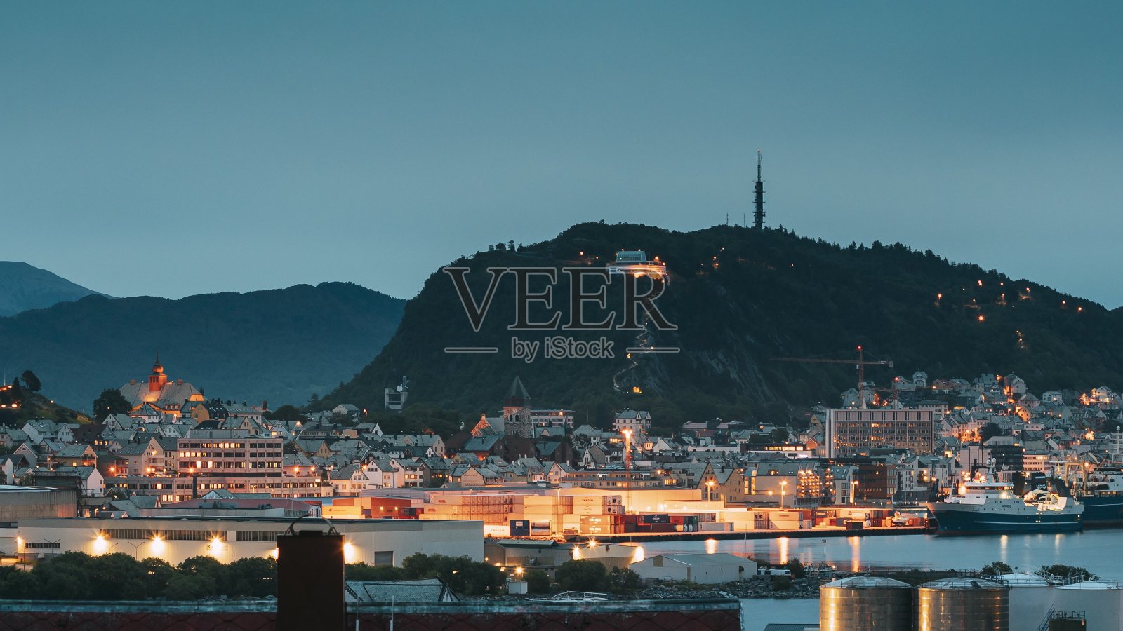 奥勒松,挪威。奥勒松天际线城市景观和港口码头在夜间照明。夏天的历史中心。著名的挪威地标和受欢迎的目的地。老奥勒松照片摄影图片