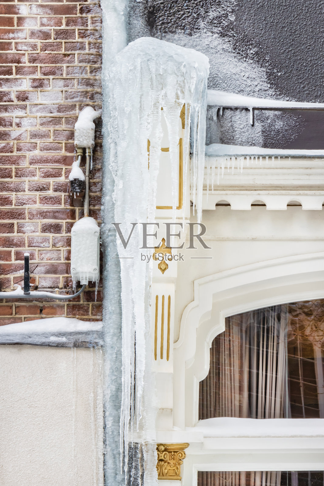 一个寒冷的冬天，荷兰多斯堡市中心的一座历史建筑上悬挂着冰柱照片摄影图片