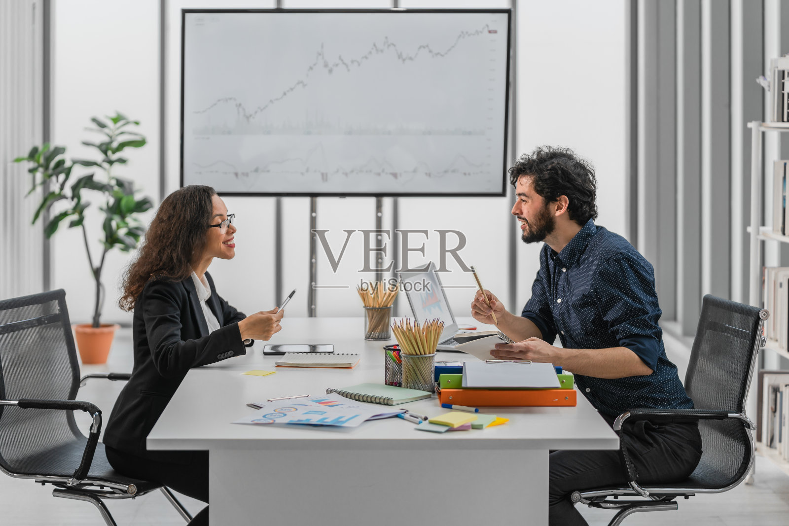 白人商人和西班牙女商人在金融和投资顾问办公室一起进行商业讨论照片摄影图片