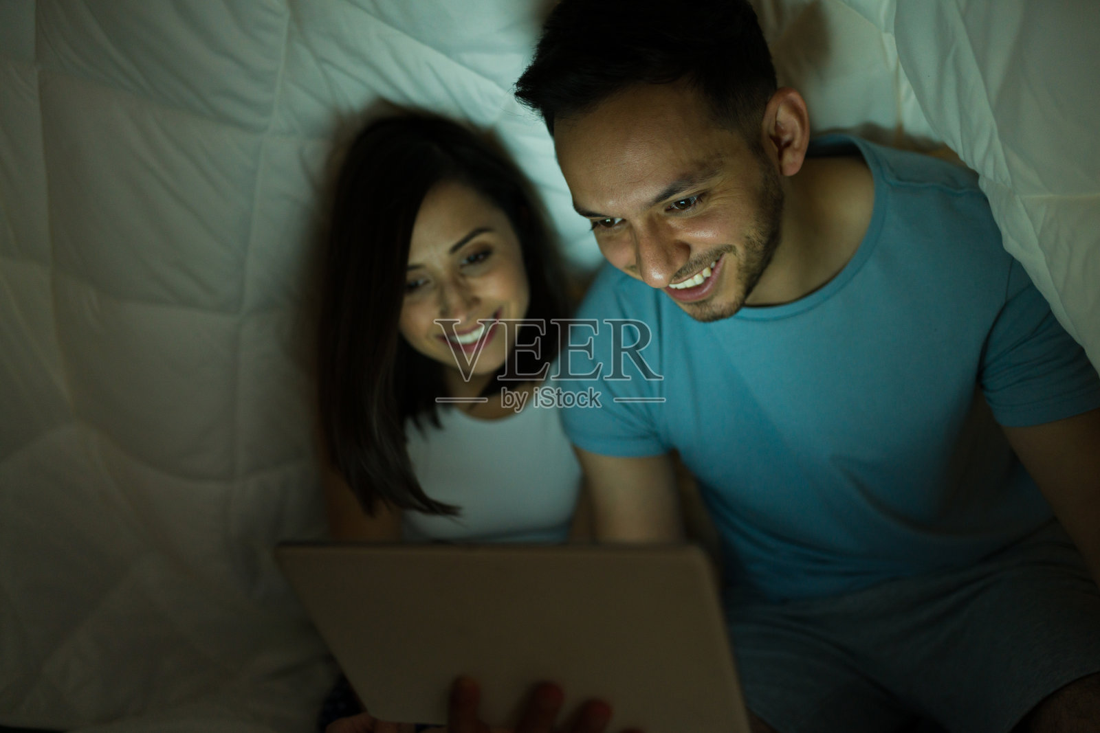 情侣在平板电脑上看电视剧照片摄影图片