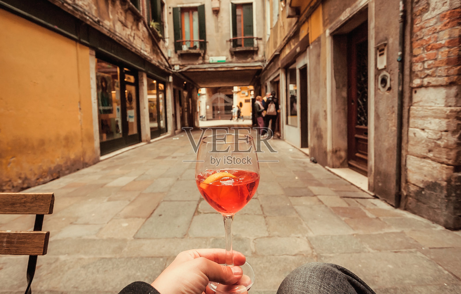 意大利某城市的游客手里拿着斯普瑞兹鸡尾酒酒杯。历史的街道之旅，一杯美味清爽的饮料照片摄影图片
