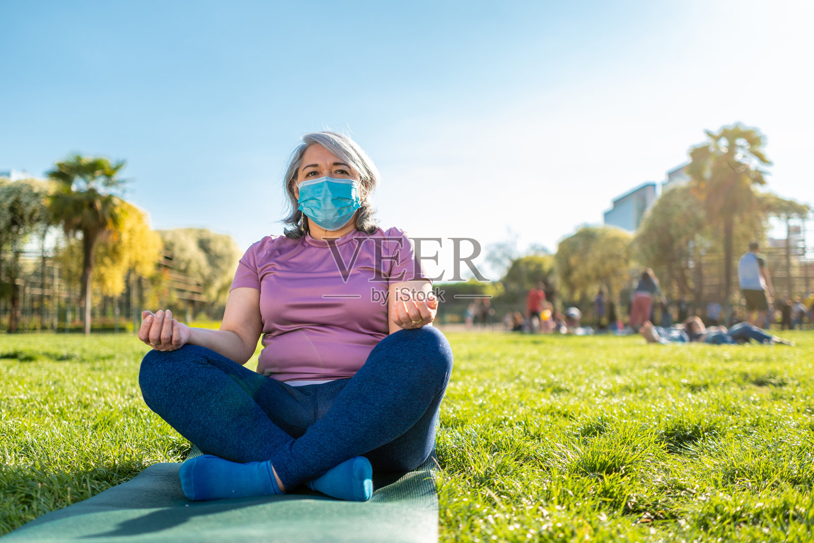 一名成年女子在城市公园戴着口罩做瑜伽照片摄影图片