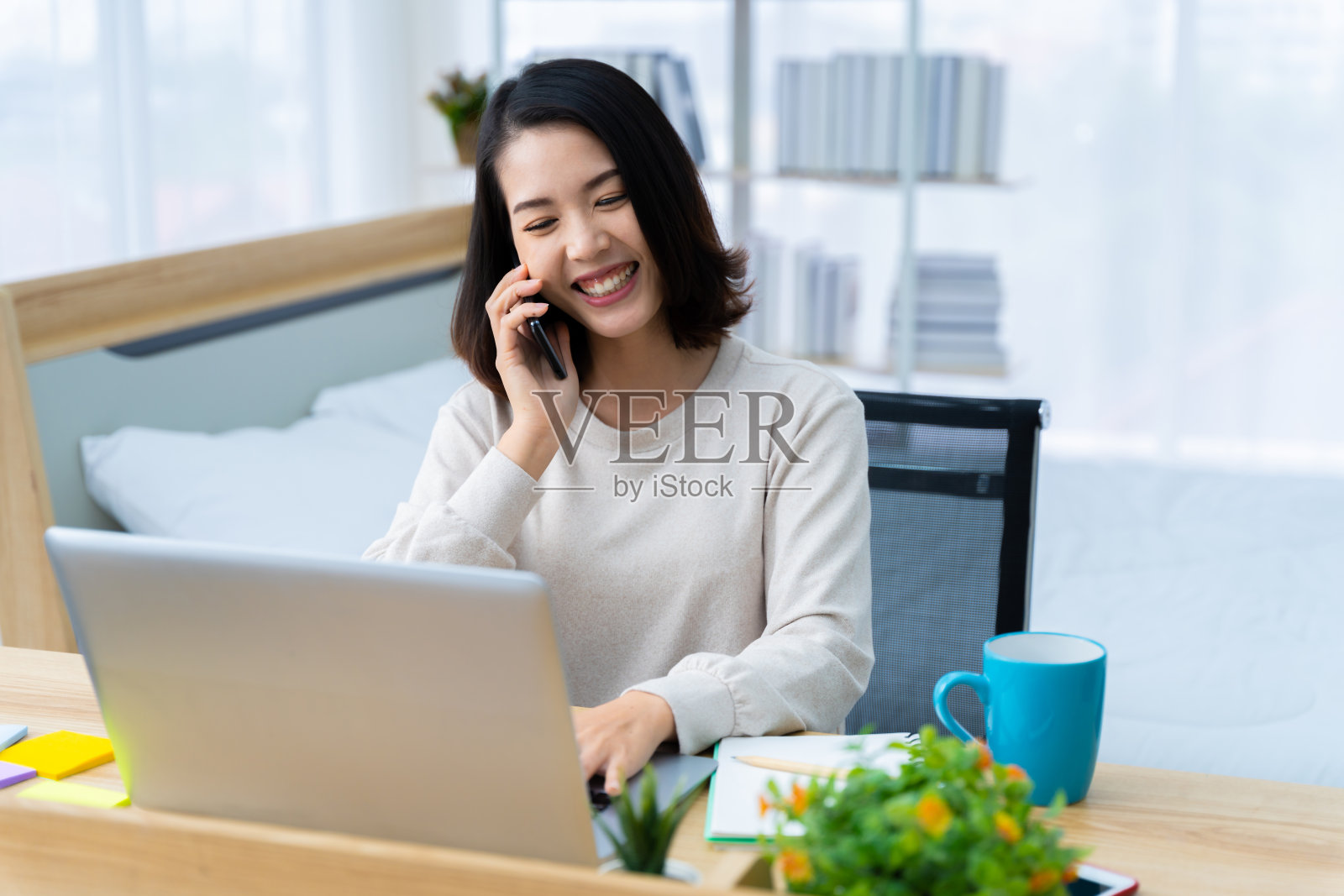 亚洲女性在家工作，打电话，在家工作愉快地工作，放松照片摄影图片