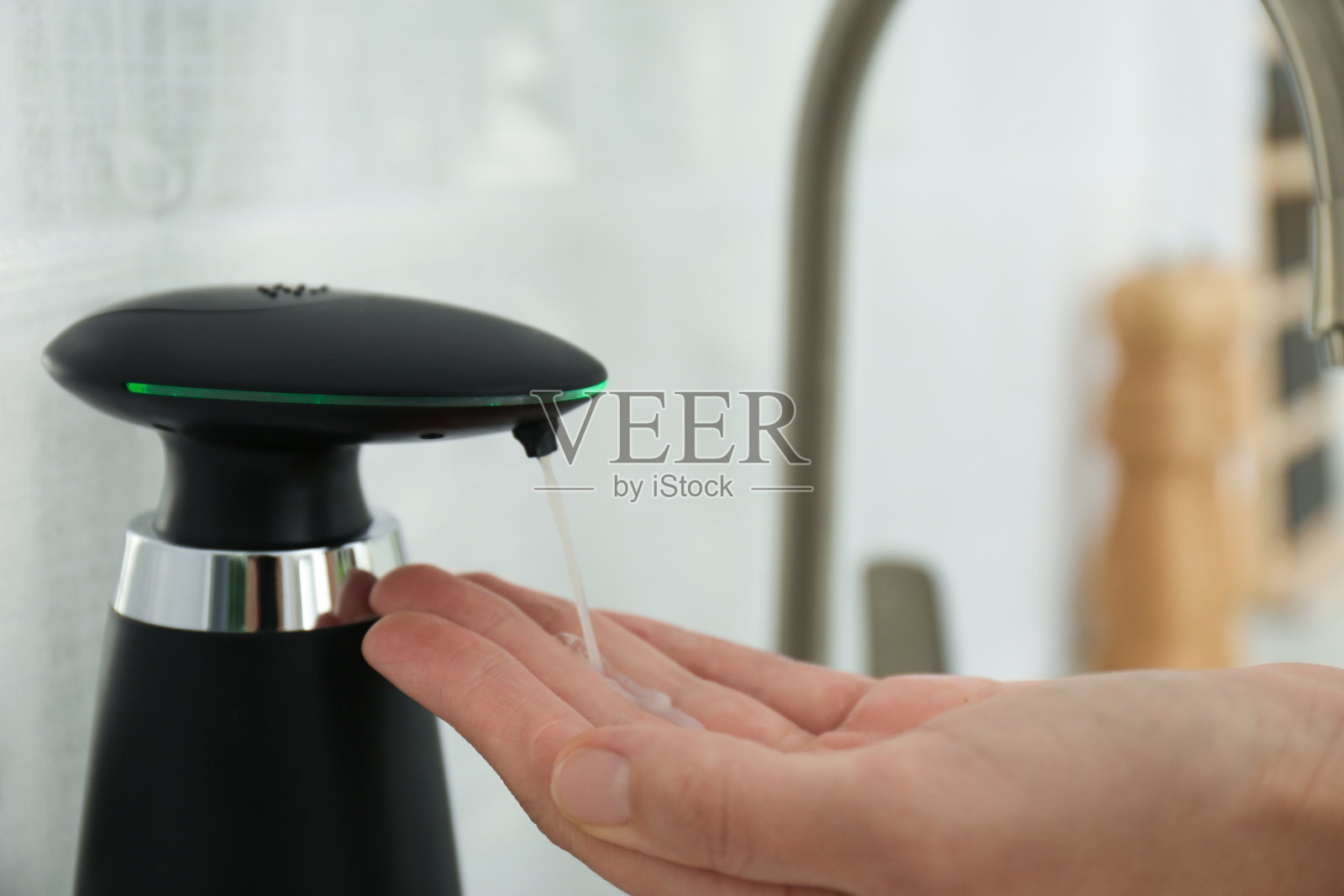 一个女人在厨房里用自动皂液机，特写镜头照片摄影图片