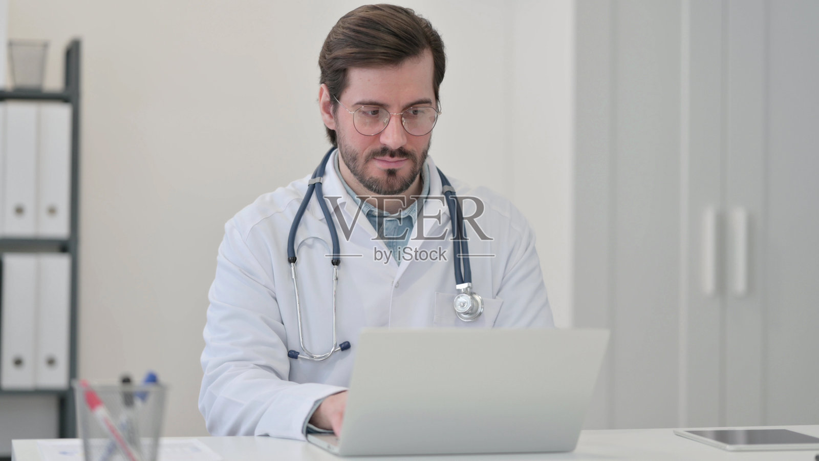 年轻的医生在笔记本电脑上工作照片摄影图片