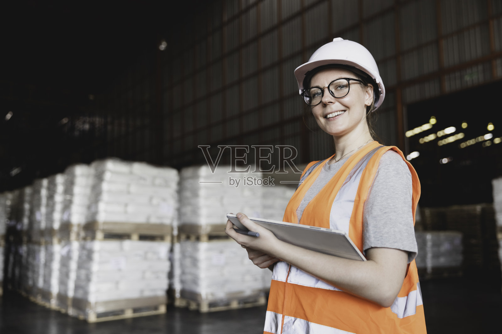 图为戴着眼镜的女职员在仓库仓库用平板电脑检查库存的照片照片摄影图片