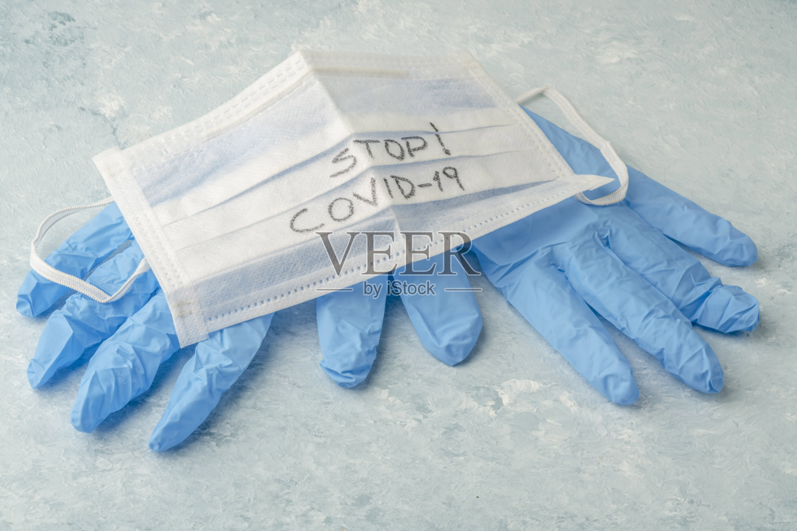 蓝色塑料手套和带有“阻止covid - 19”标志的一次性健康口罩照片摄影图片