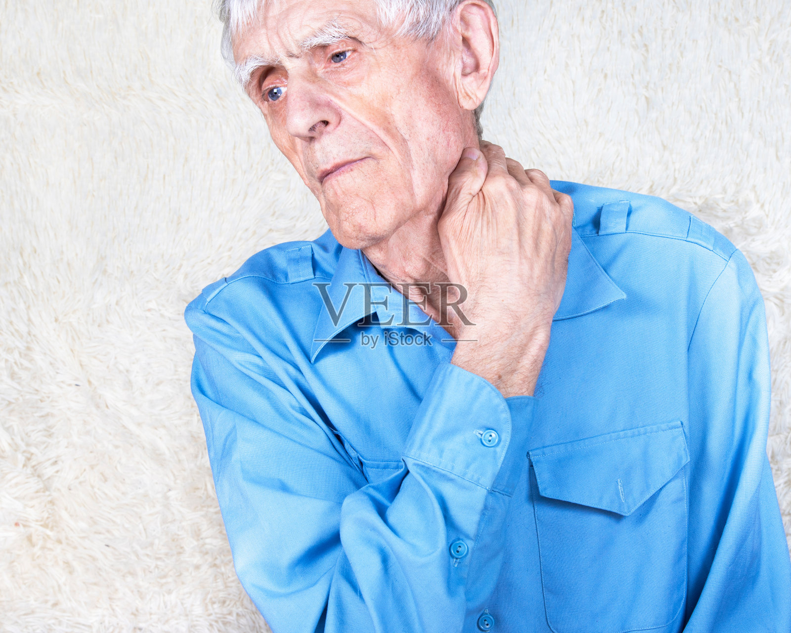 老人患有颈椎病、骨软骨病。男性双手托着脖子。白色背景照片摄影图片