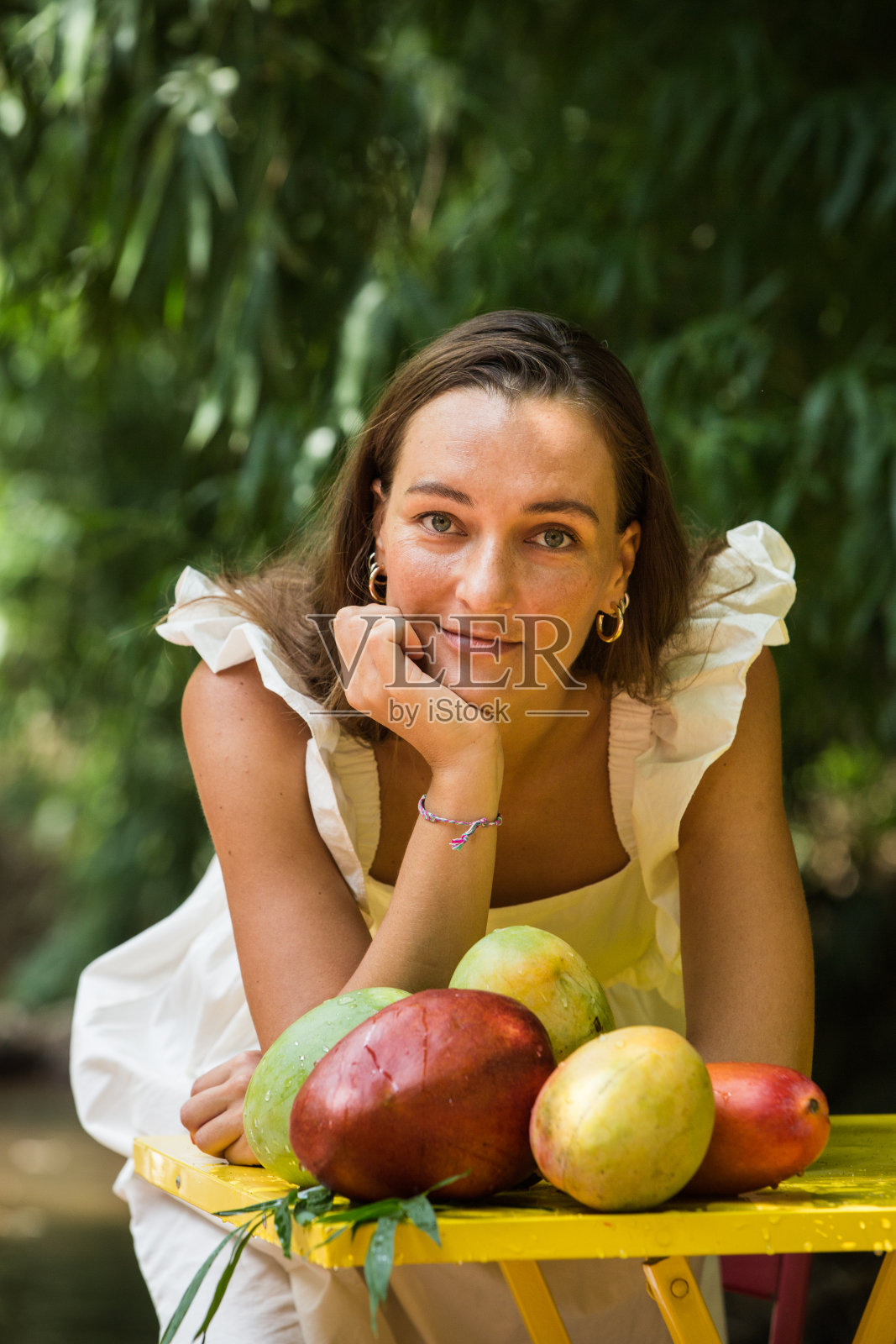 树下有芒果的女人，素食的概念照片摄影图片