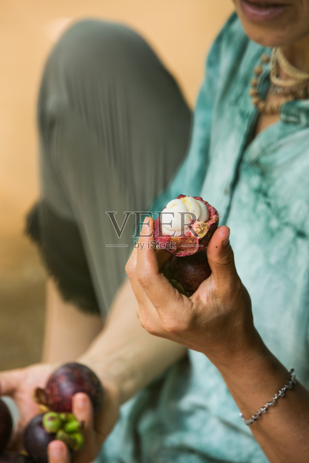 大自然中的女人手里拿着山竹，素食的概念照片摄影图片