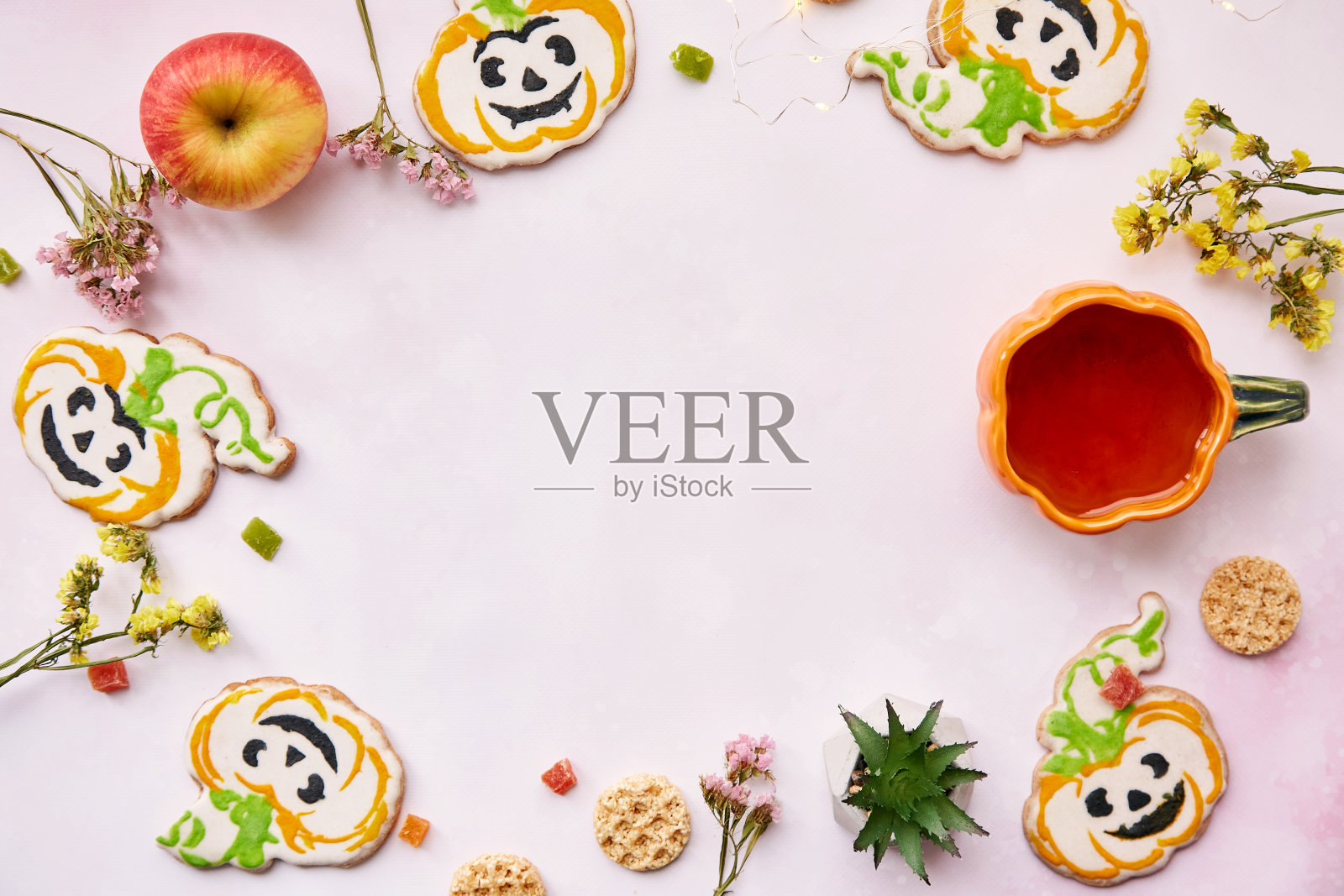 万圣节创意概念背景:可爱的南瓜形状的南瓜杯和饼干。副本的空间。大气美学的秋季意境还是恶作剧或款待的概念。苹果、干花和蜜饯水果照片摄影图片