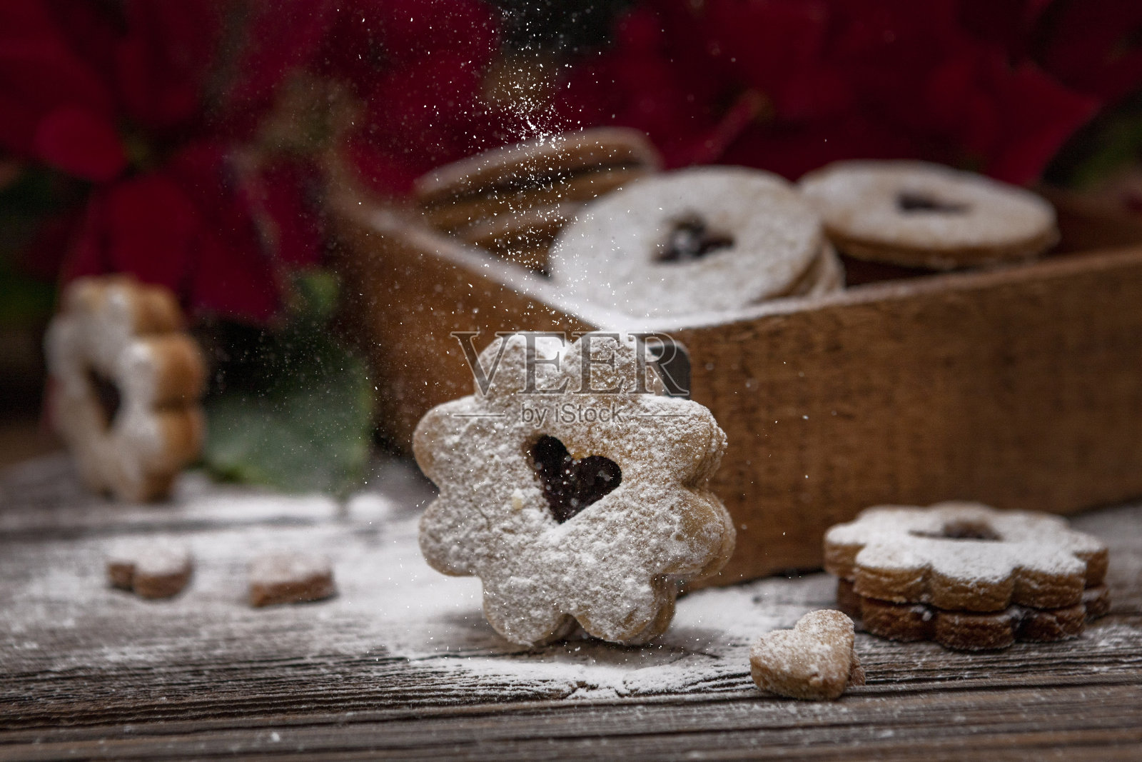 传统圣诞节自制林瑟饼干洒上糖霜在木盒和一品红花。特写,有选择性的重点。照片摄影图片