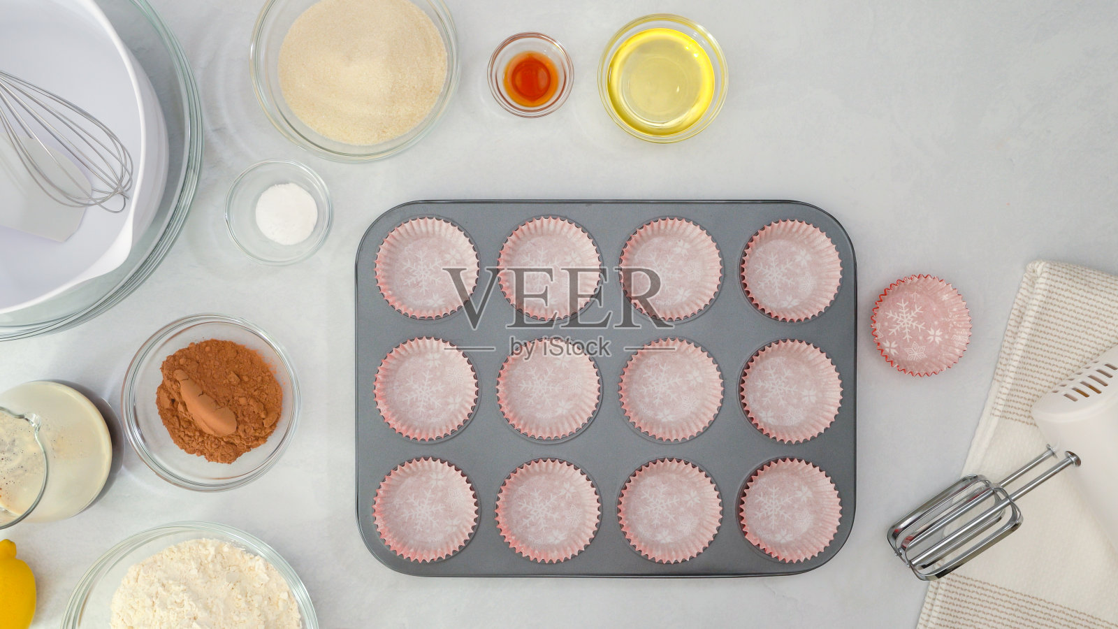 带纸杯蛋糕衬垫的松饼盘，以及制作巧克力松饼的原料就在厨房的桌子上照片摄影图片