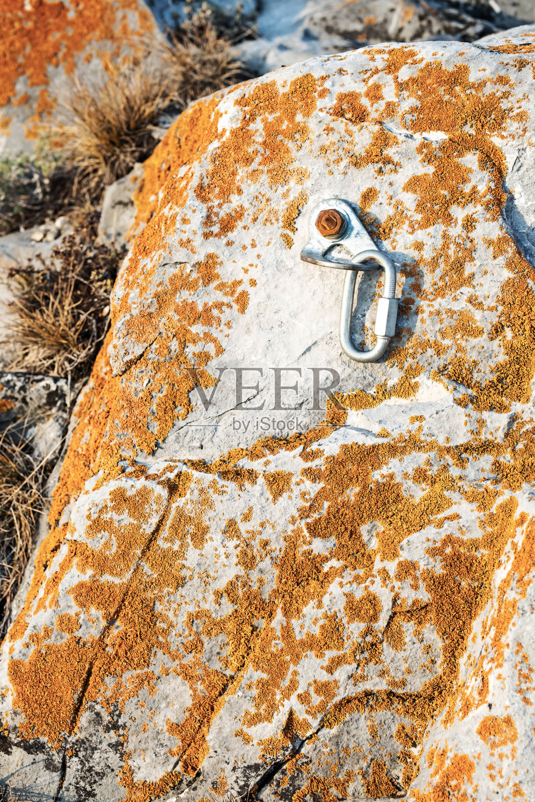 Сlimbing锁钩和触发装置在石头。用于在岩石背景上登山的钩环。极限运动的概念。照片摄影图片