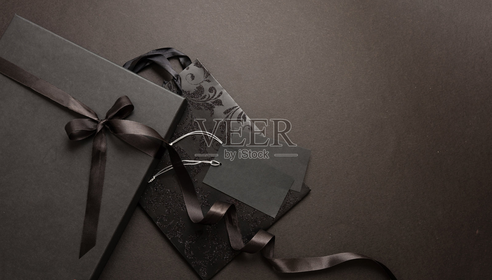 黑色星期五促销概念。黑色背景的黑色购物袋和礼品盒。照片摄影图片