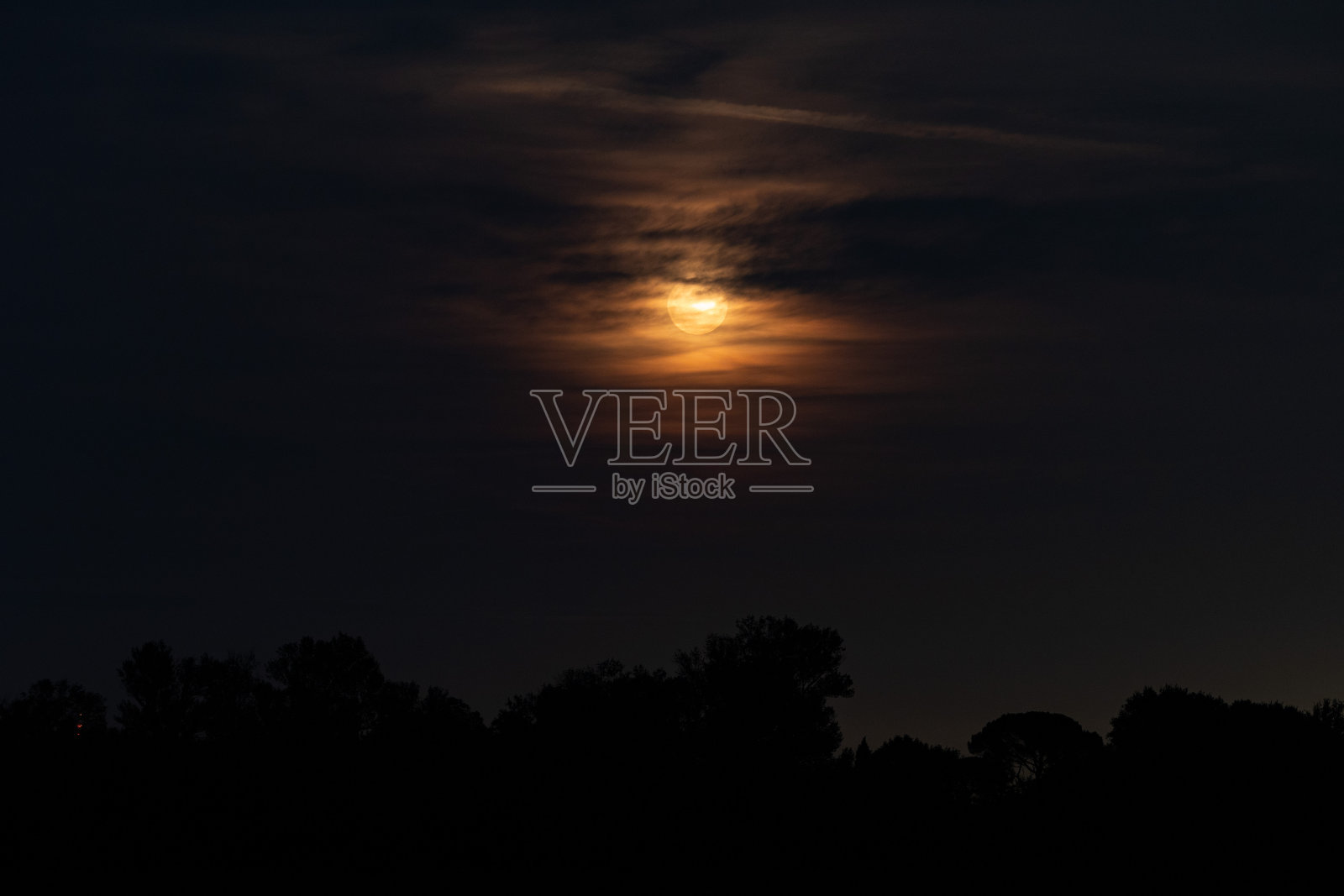 夏末，乌云密布的天空中挂着美丽的橙色月亮照片摄影图片