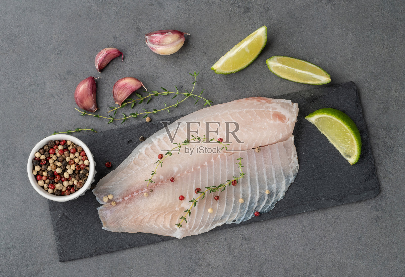 生罗非鱼片与调味在石头背景照片摄影图片