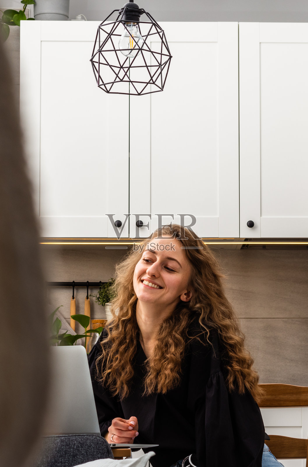 纵向肖像的快乐微笑的年轻女子棕色长发，家庭生活方式，重点背景。照片摄影图片