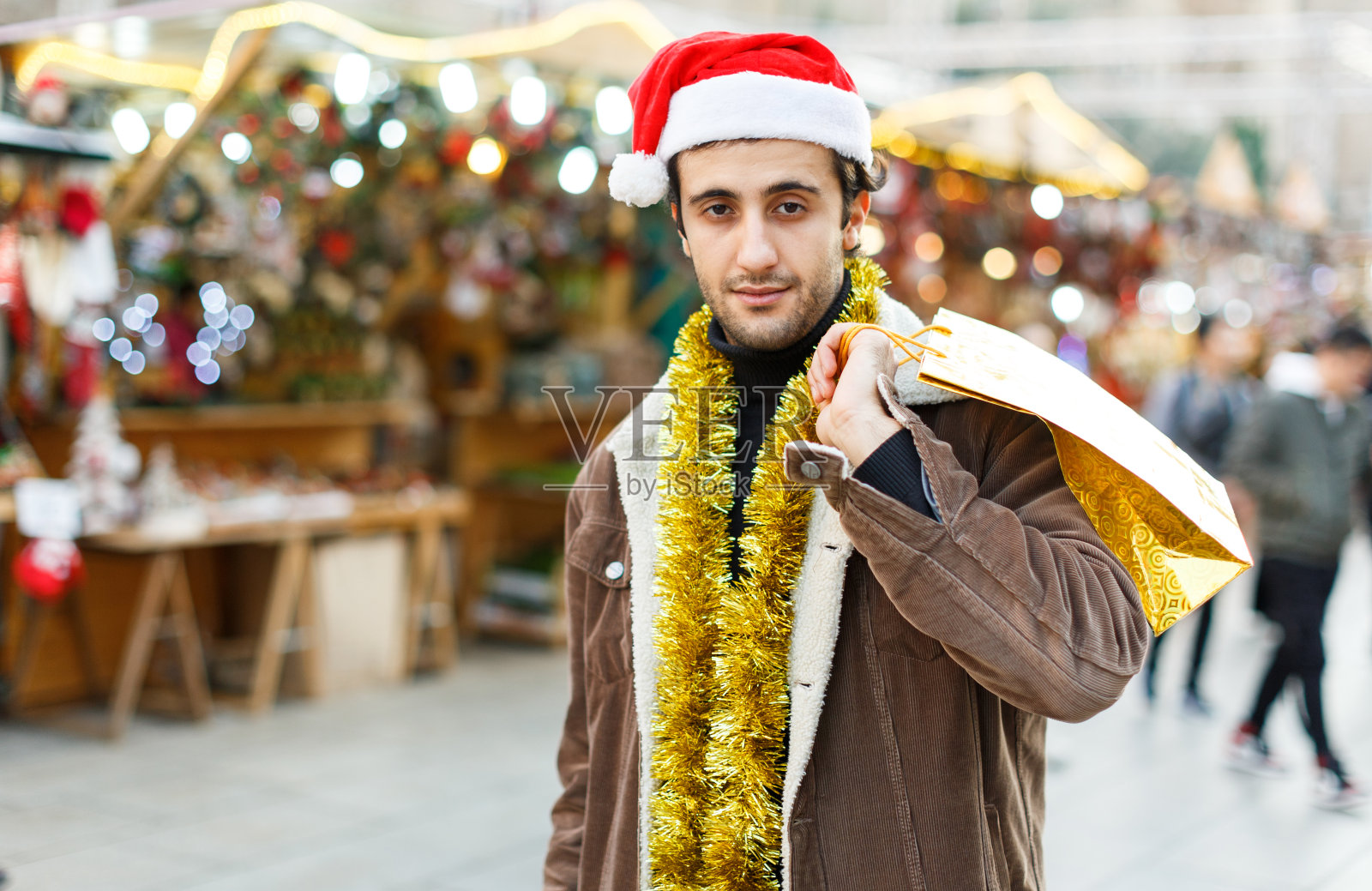 戴着圣诞帽的人在圣诞集市上兴高采烈地买着东西照片摄影图片