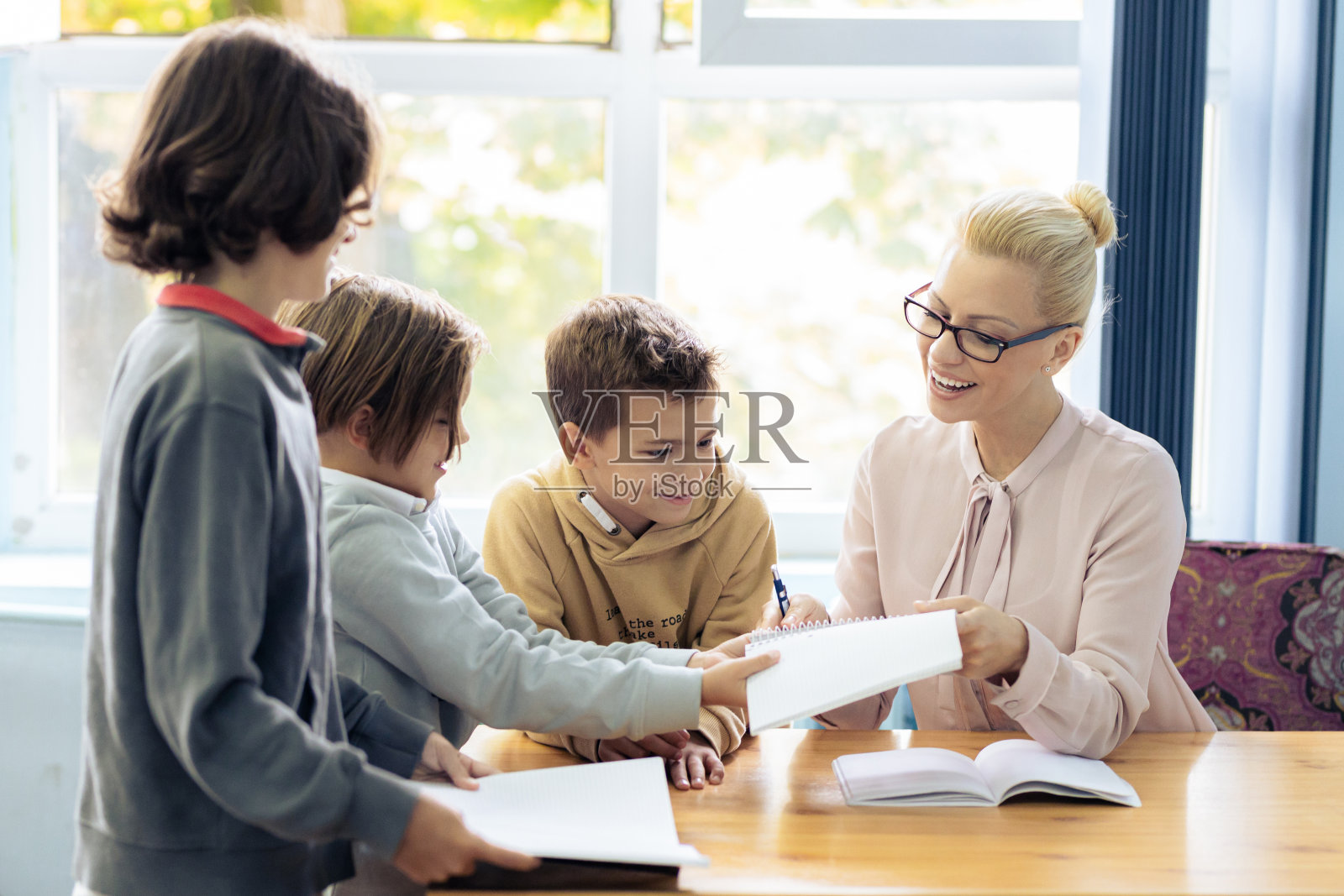 在课堂上帮助男生的老师照片摄影图片