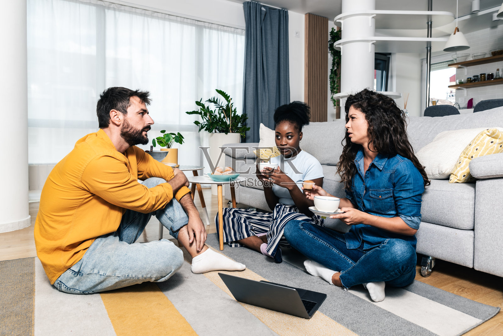 三位年轻的好朋友和商业伙伴坐在公寓里，庆祝他们在网站上的第一次网上销售。他们创办的公司是一家小型网上购物公司照片摄影图片