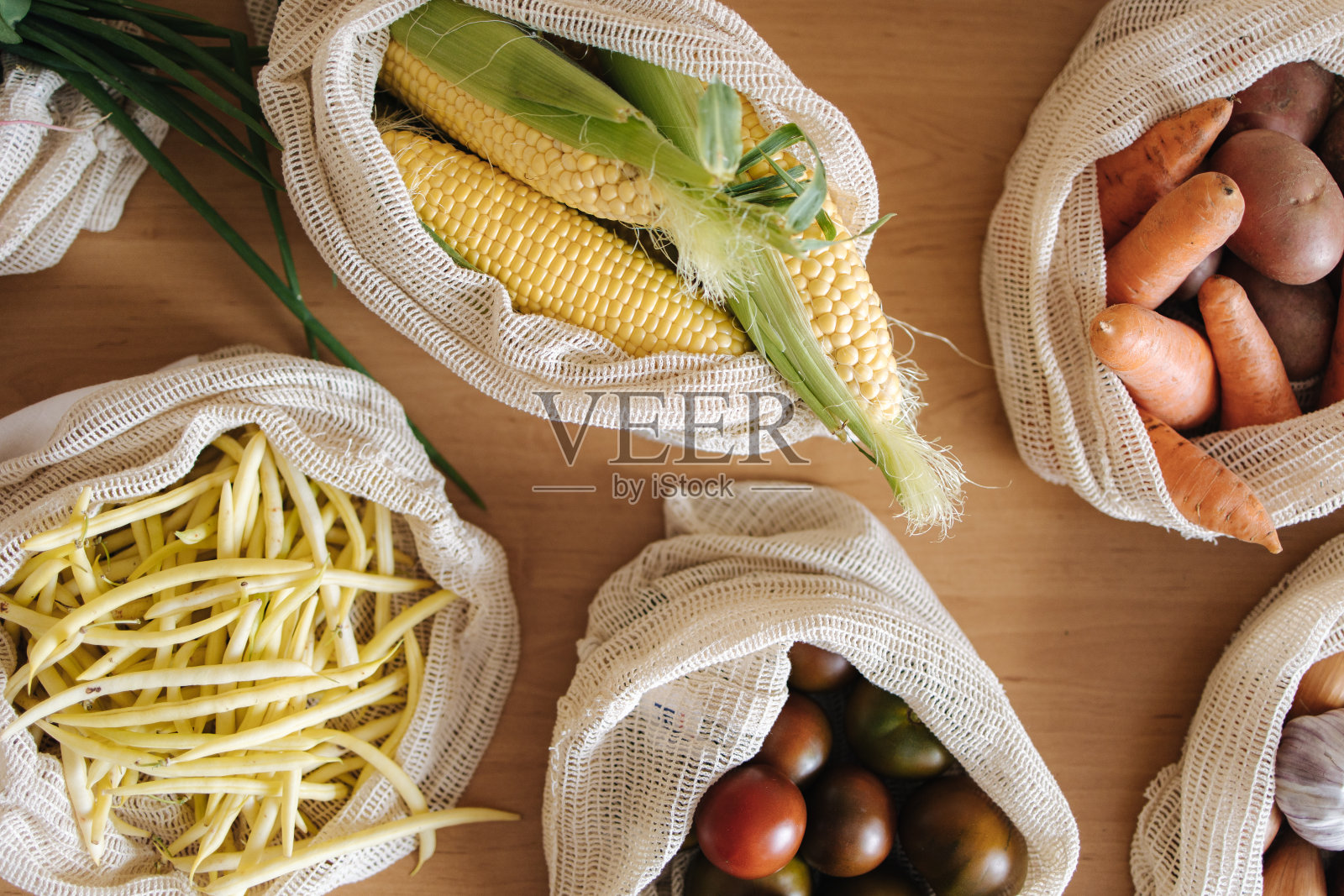 木桌上可重复使用的生态棉袋蔬菜的俯视图。零浪费购物理念。帆布杂货袋与西红柿，胡萝卜，土豆。塑料免费项目照片摄影图片