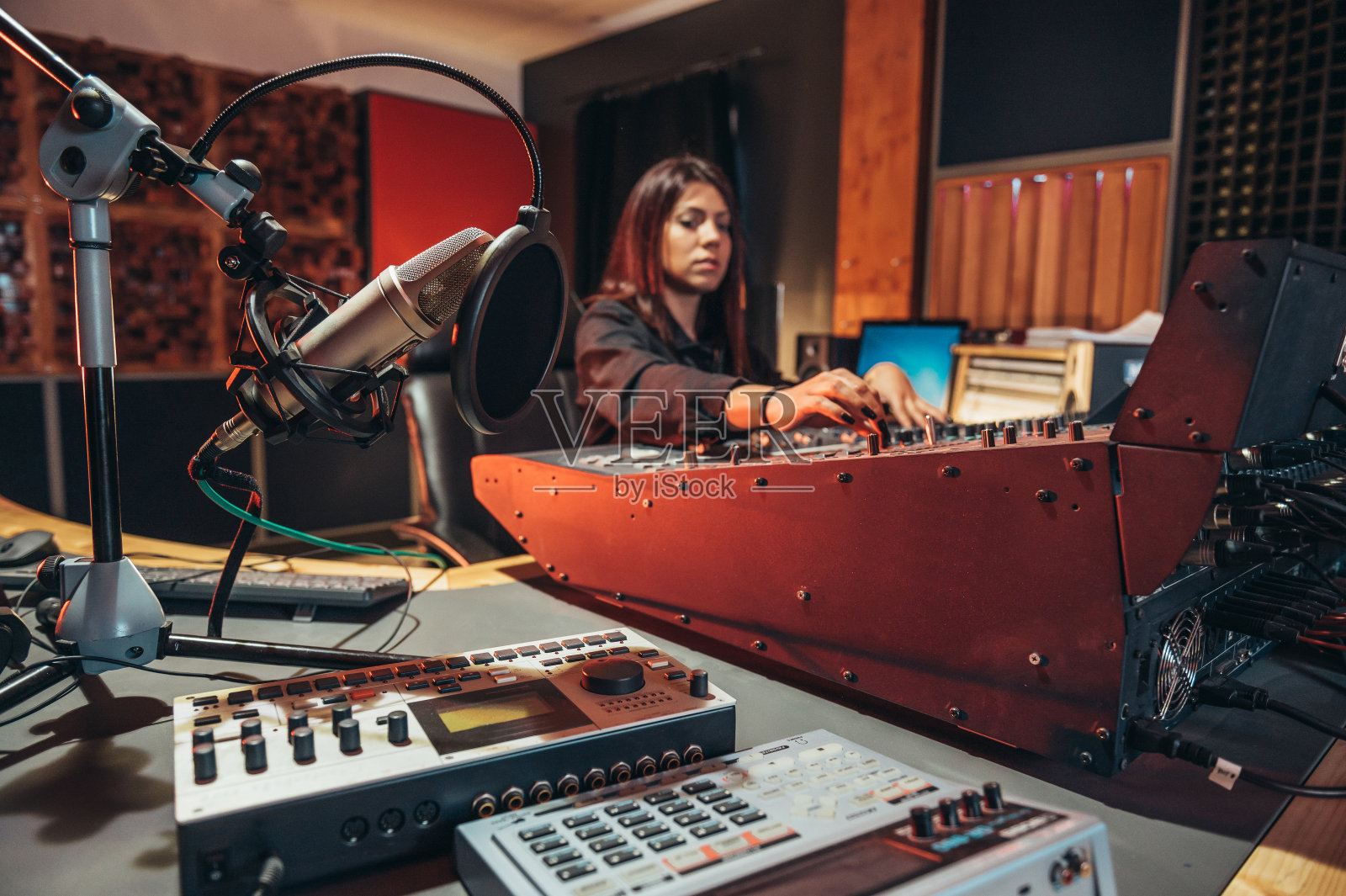 一位女音乐制作人在她的工作室里制作混音音板照片摄影图片