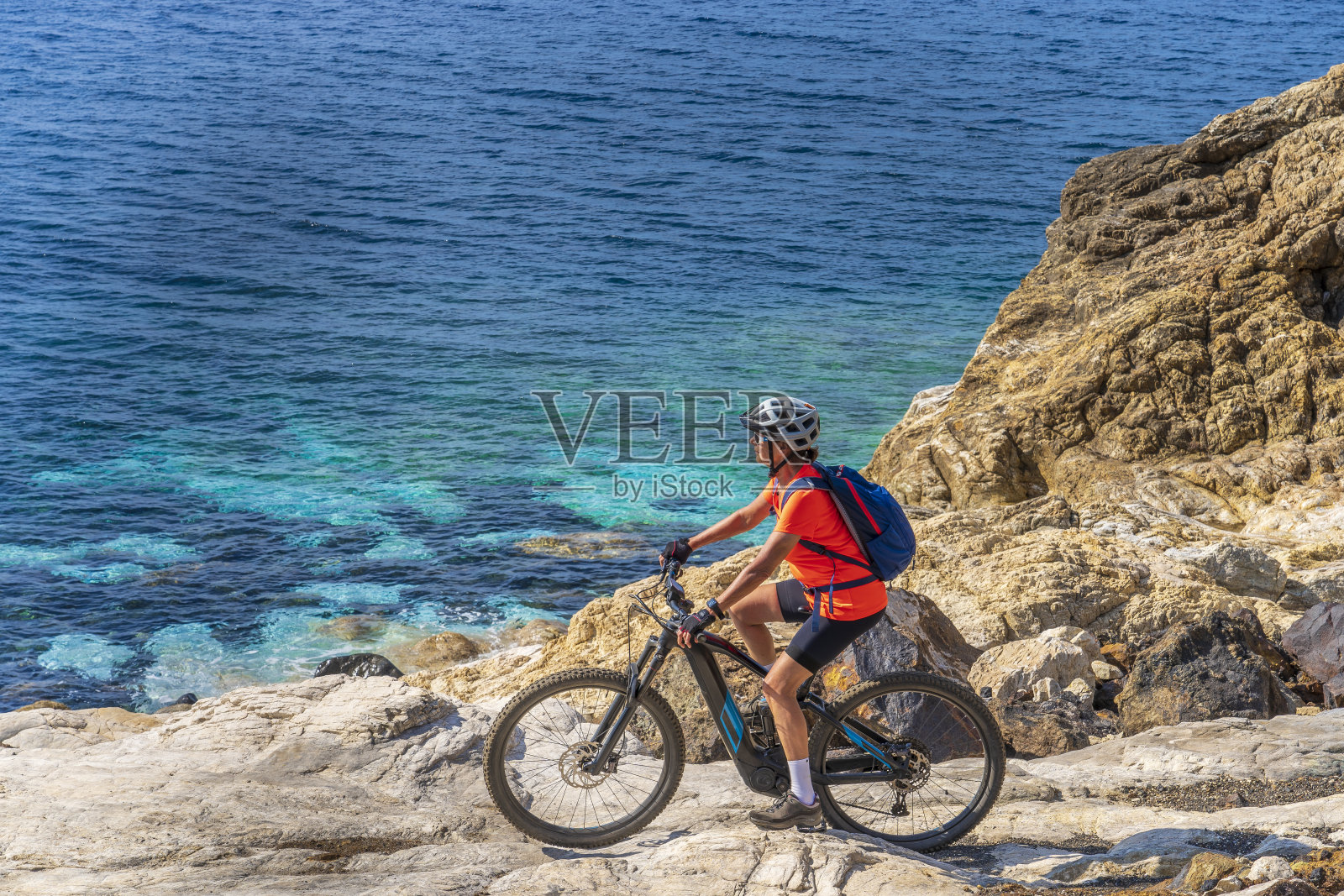 在意大利托斯卡纳的厄尔巴岛的海岸线上，一名女子骑着电动登山车照片摄影图片