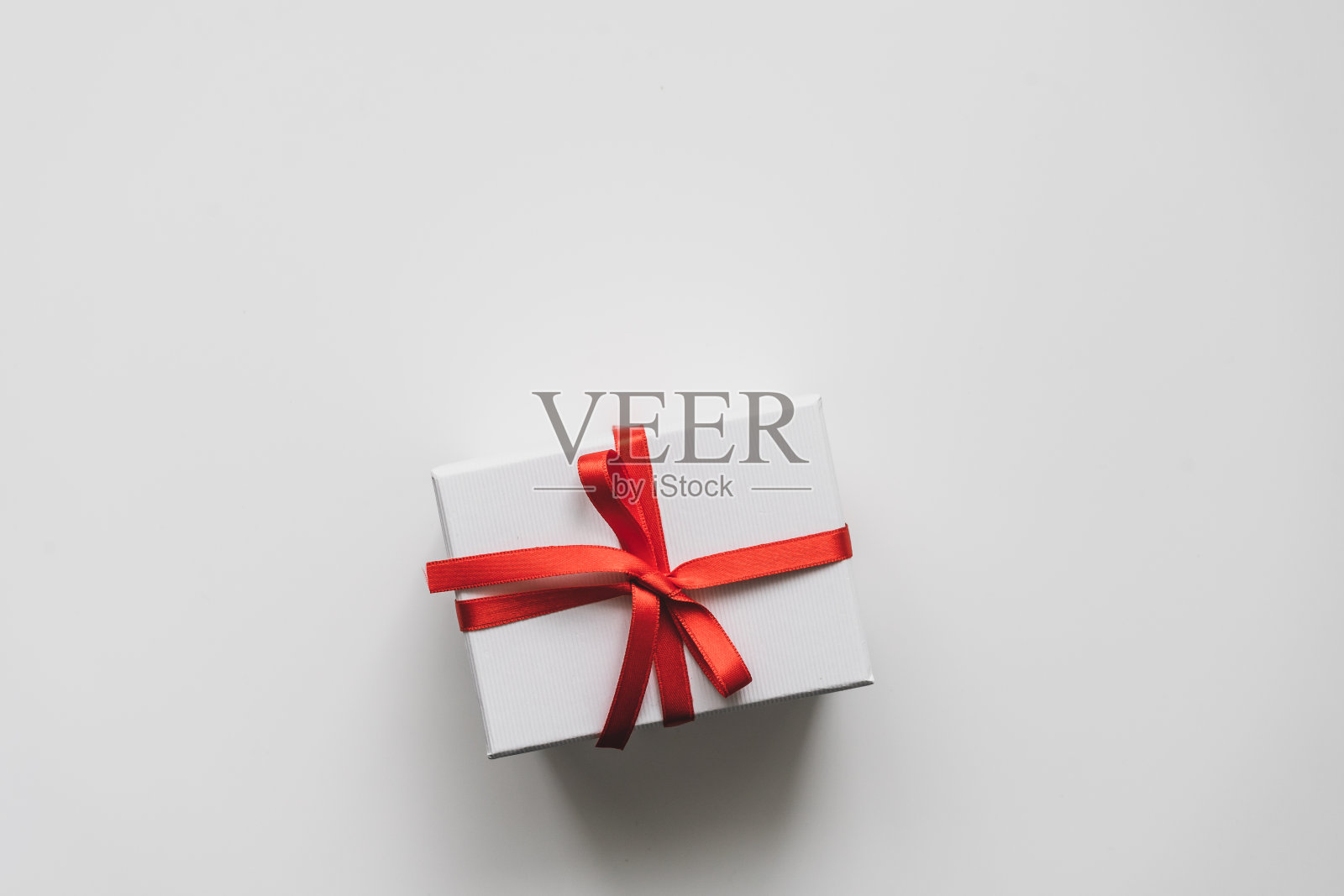 白色背景上有红色蝴蝶结的礼品盒照片摄影图片