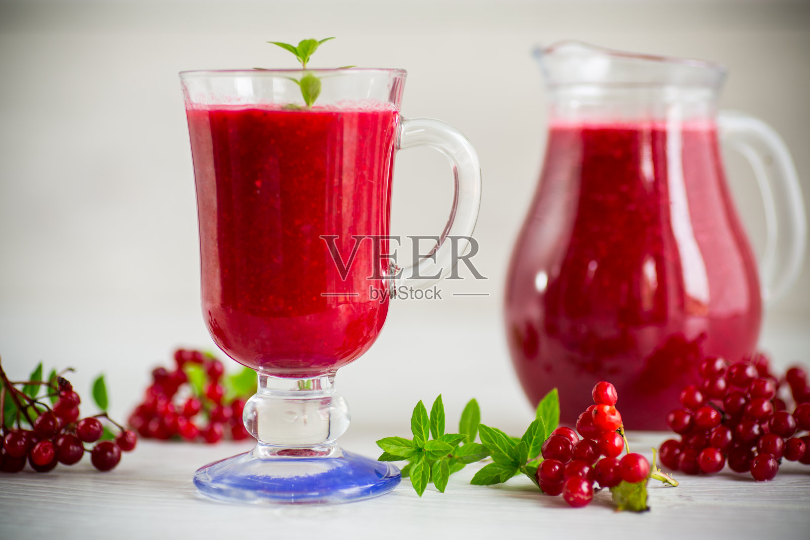 鲜榨的浓汁和果肉从成熟的红色荚蒾在醒酒器照片摄影图片