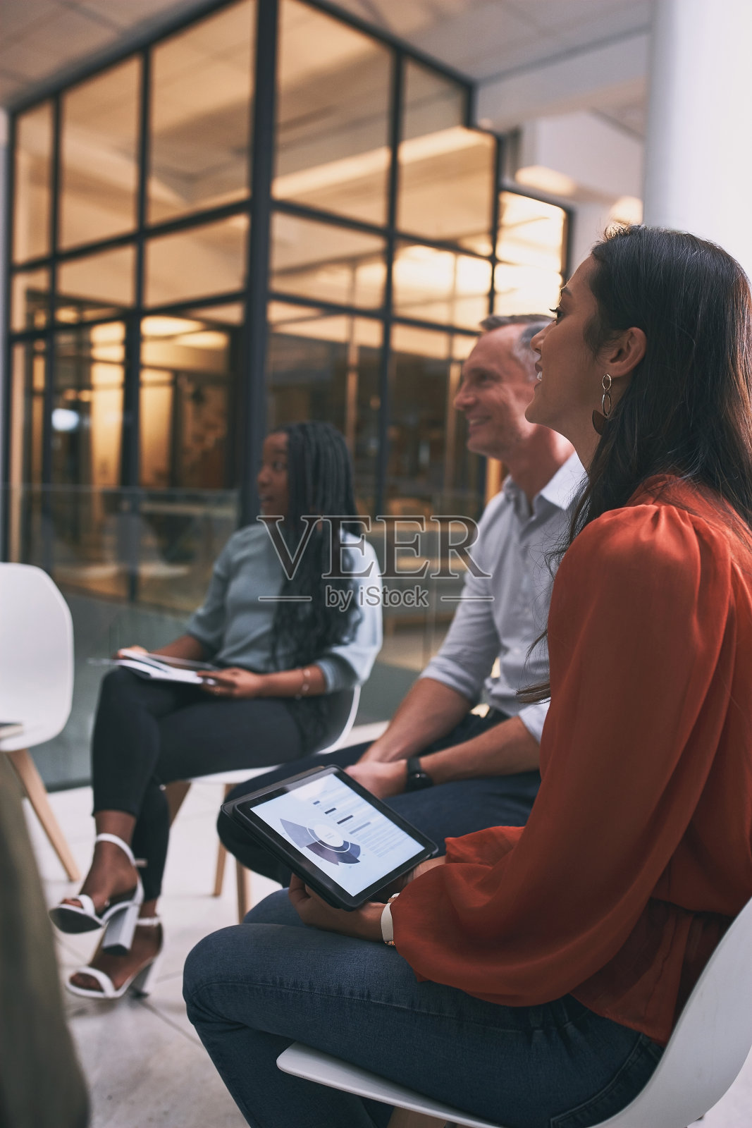 一名年轻女子在团队会议上使用平板电脑照片摄影图片