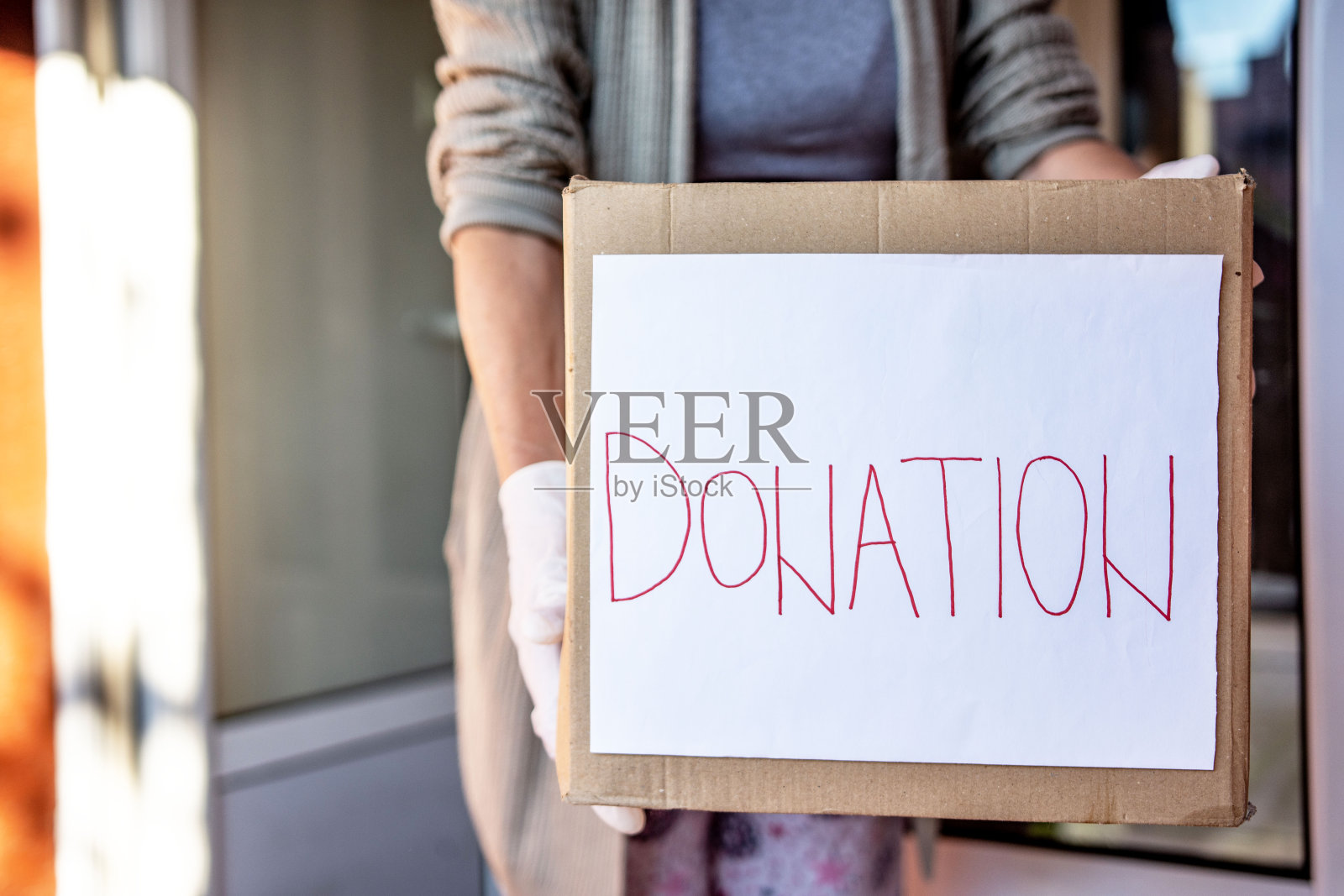 一位老妇人拿着一盒捐赠的食物照片摄影图片