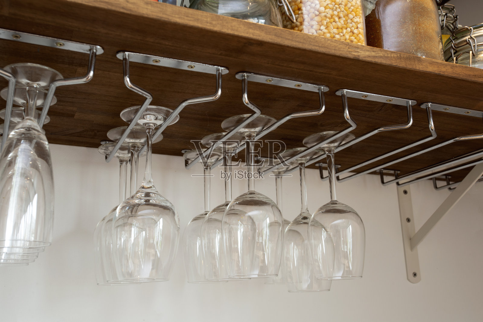 酒杯挂在杯架上。组织在柜子里。家庭内部存储照片摄影图片