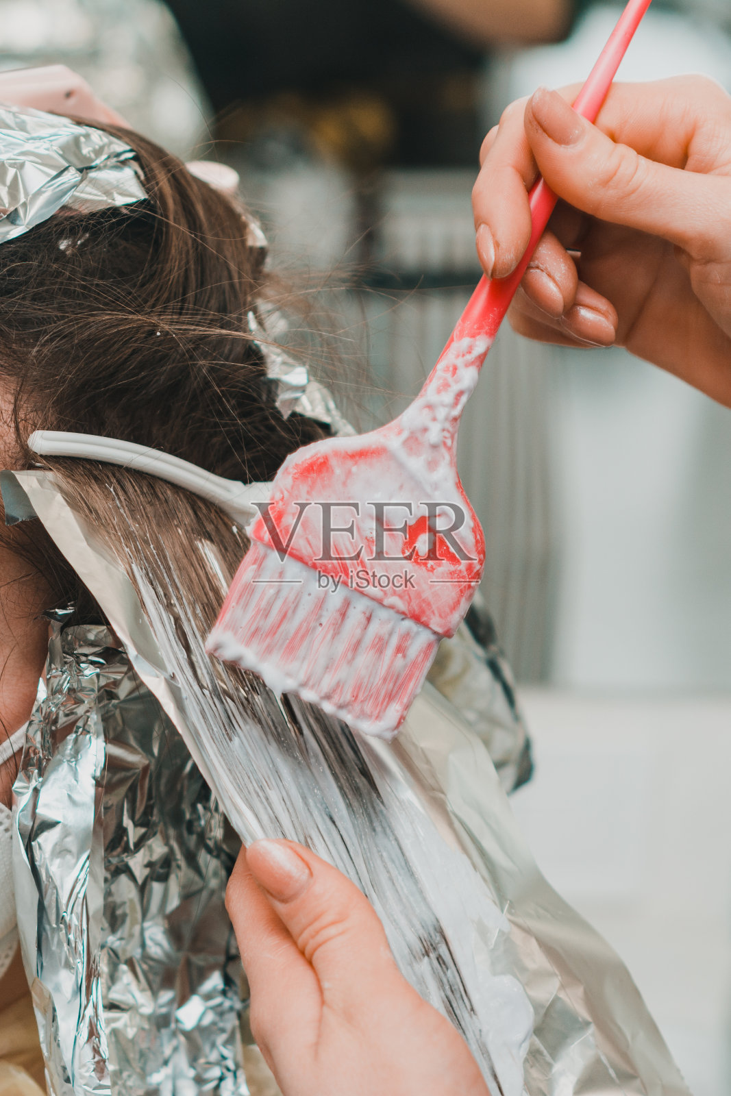 一个女人在理发店里染发，用箔纸染发。照片摄影图片