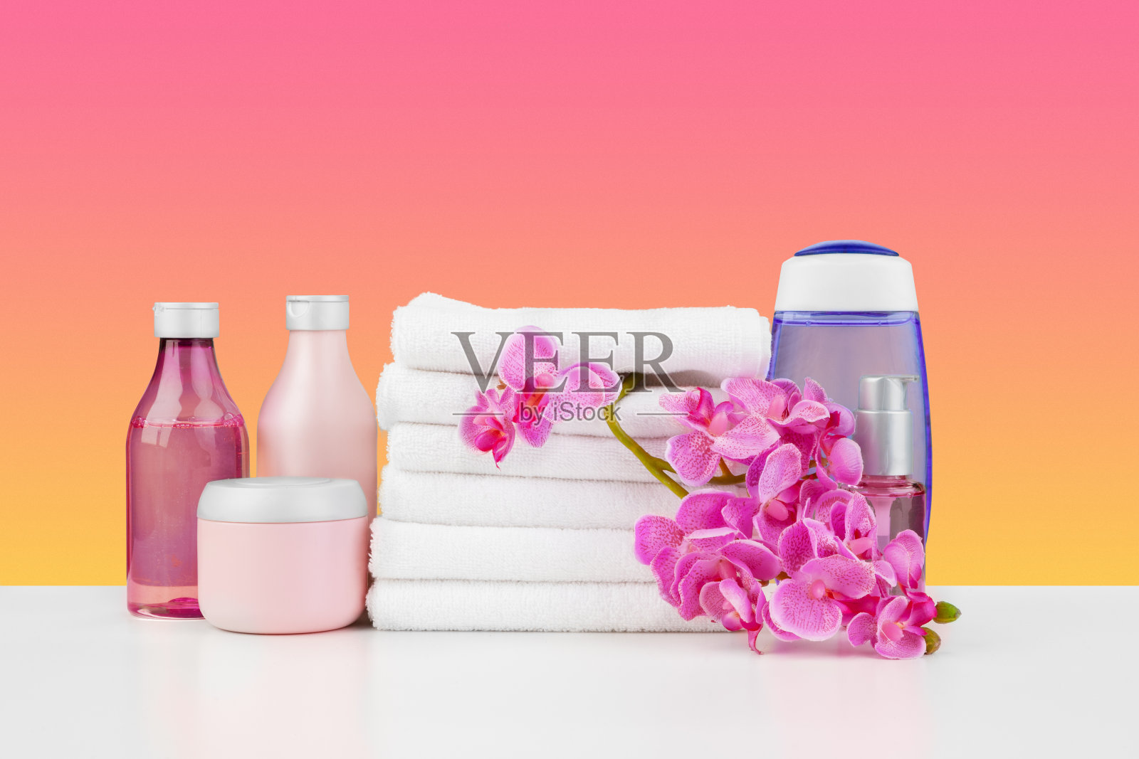 白色的桌子上堆放着白色的毛巾和护肤用品照片摄影图片