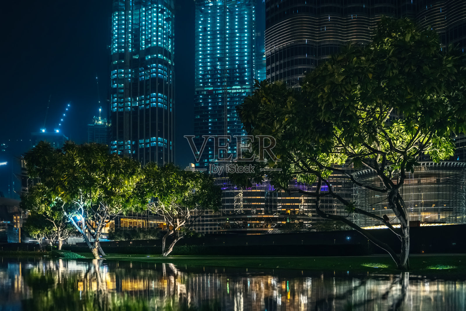 迪拜市中心夜景：水中倒影与高楼背景照片摄影图片