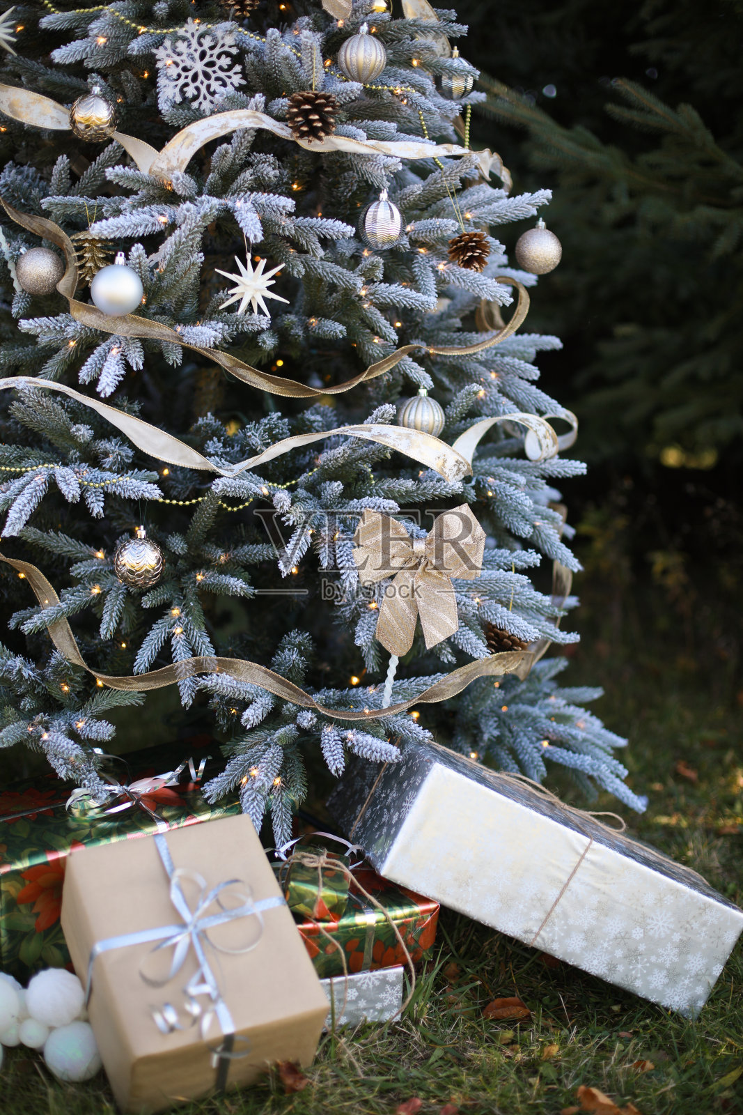 蓝色装饰圣诞树与装饰球和花环，礼物盒和礼物附近照片摄影图片