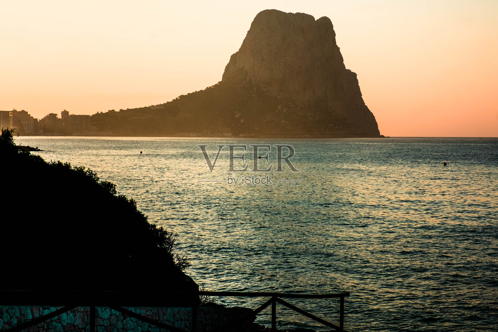 日出时分，西班牙阿利坎特地中海沿岸的卡尔佩，可以看到Peñon de Ifach照片摄影图片