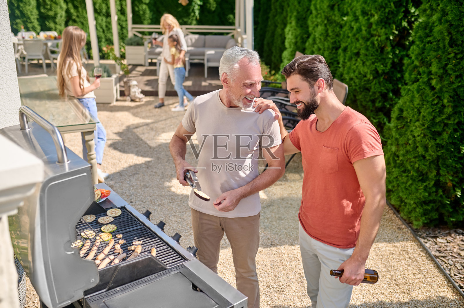爸爸和儿子在后院一起做饭照片摄影图片