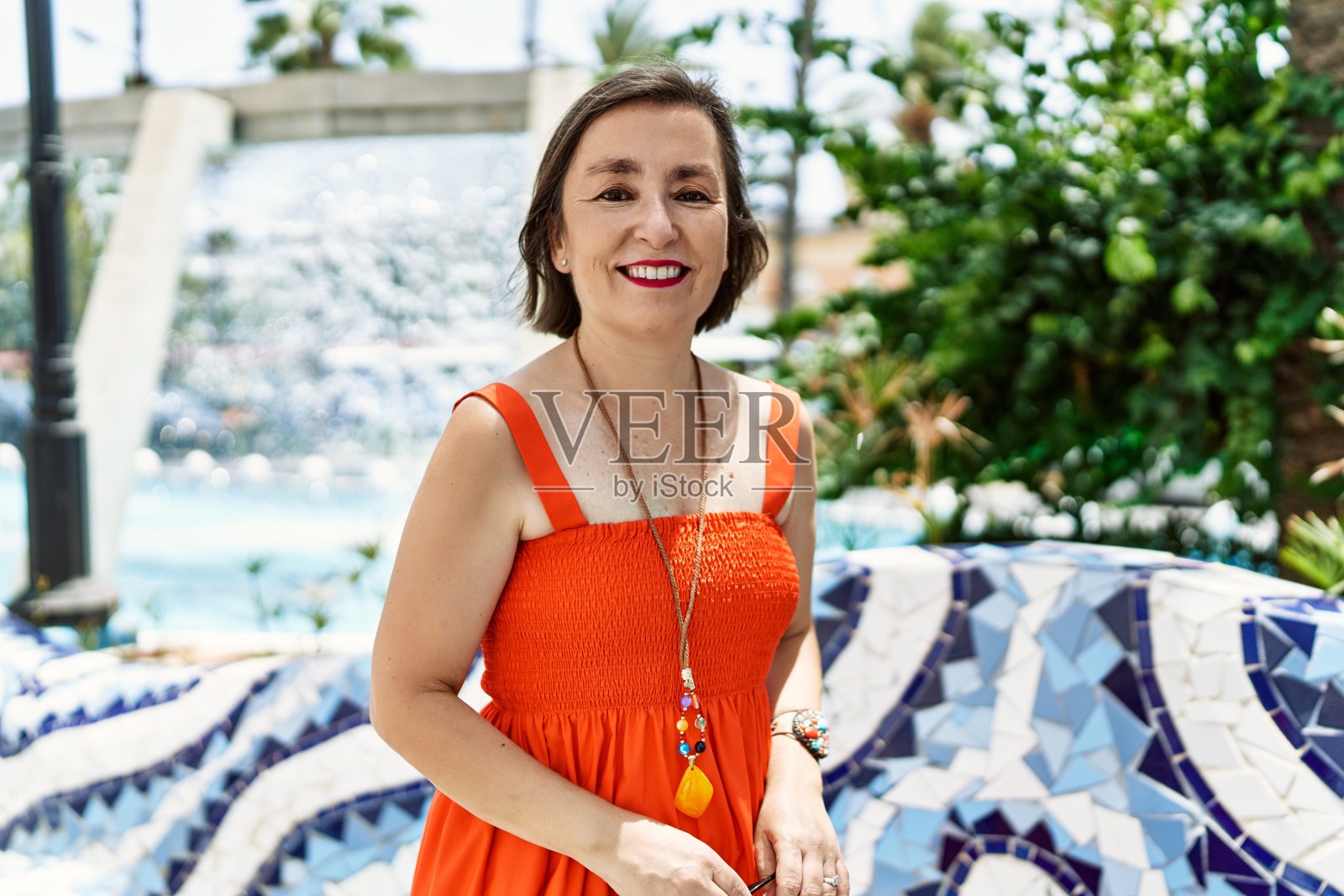 中年西班牙妇女微笑着，在城市的户外快乐和自信照片摄影图片